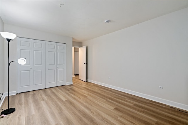 unfurnished bedroom with a closet and light hardwood / wood-style flooring