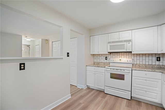 kitchen featuring white cabinets, light hardwood / wood-style floors, white appliances, and tasteful backsplash