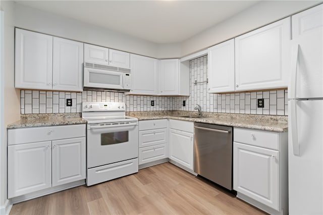 kitchen featuring white appliances, sink, white cabinetry, light hardwood / wood-style flooring, and backsplash