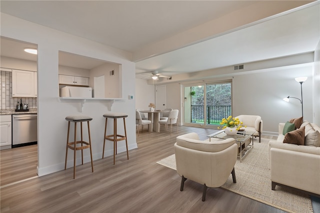 living room with light hardwood / wood-style flooring and ceiling fan