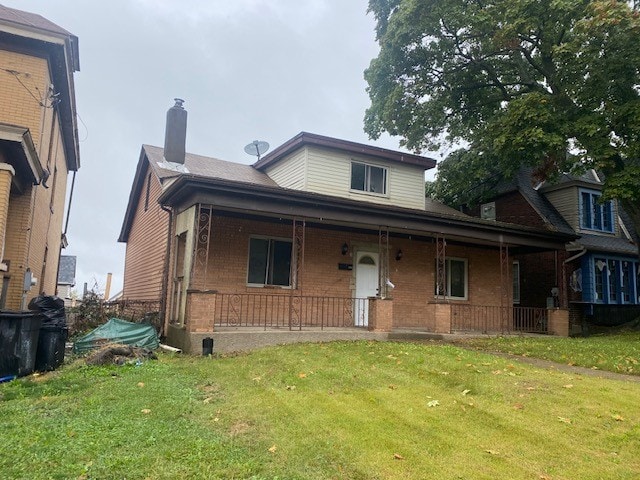 view of front of property featuring a front lawn and covered porch