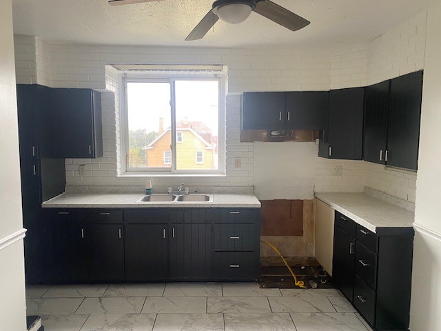 kitchen featuring ceiling fan, sink, and tasteful backsplash