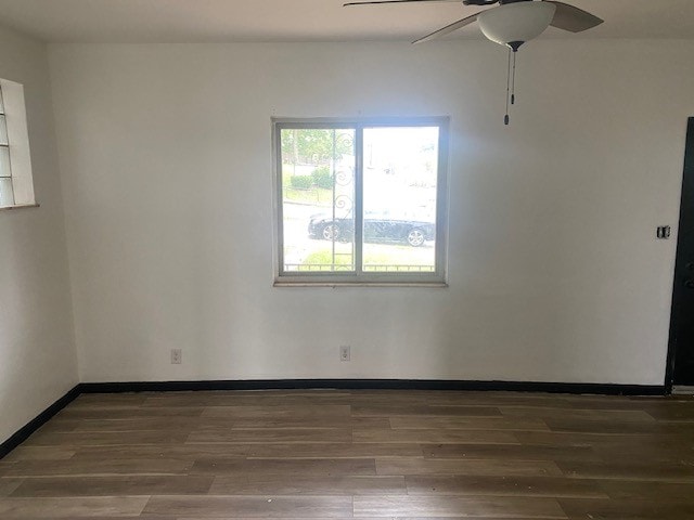 spare room featuring ceiling fan and dark wood-type flooring