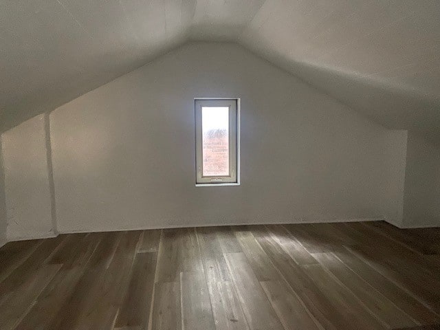 additional living space with lofted ceiling and dark hardwood / wood-style floors