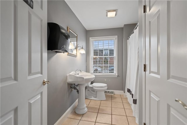 bathroom with toilet, tile patterned floors, and sink