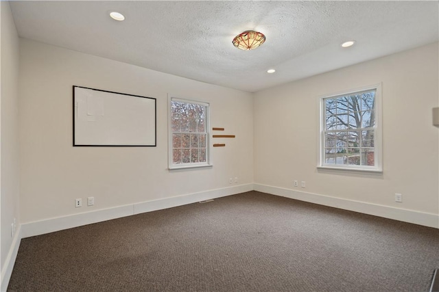 unfurnished room featuring a textured ceiling and carpet floors