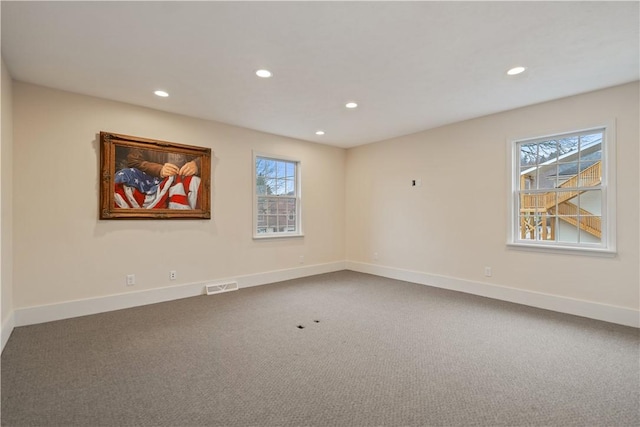 unfurnished room featuring plenty of natural light and carpet floors