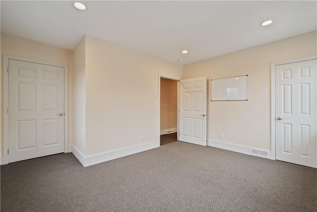 unfurnished bedroom featuring dark colored carpet