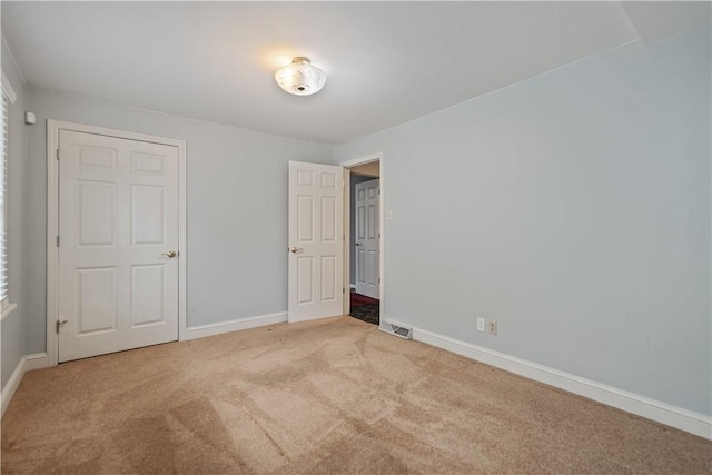 unfurnished bedroom with light colored carpet