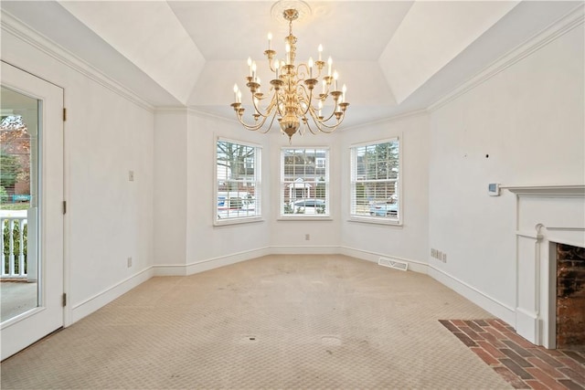 unfurnished dining area with a raised ceiling, carpet floors, crown molding, and an inviting chandelier