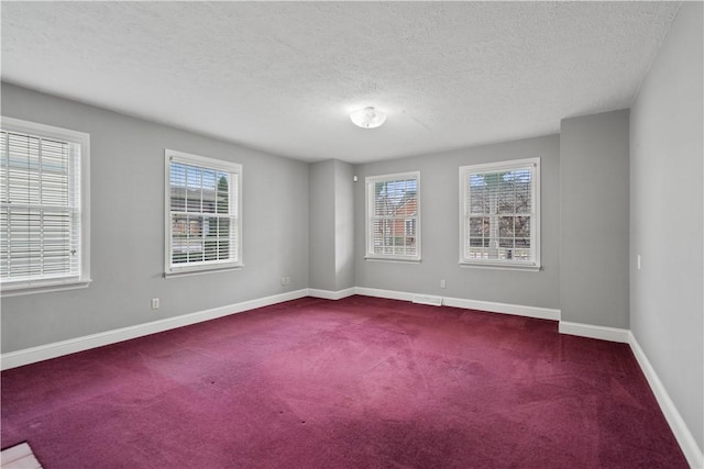 empty room featuring dark colored carpet and a textured ceiling