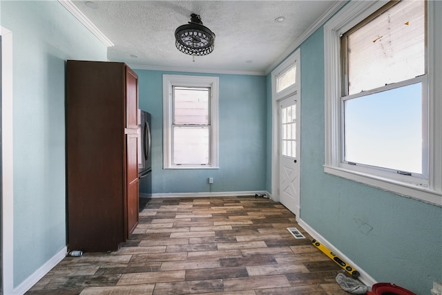 interior space featuring a textured ceiling, crown molding, and dark wood-type flooring