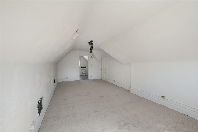 bonus room featuring vaulted ceiling and light carpet