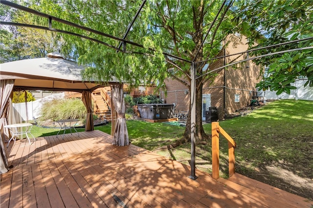 wooden deck with a gazebo, a yard, and a hot tub