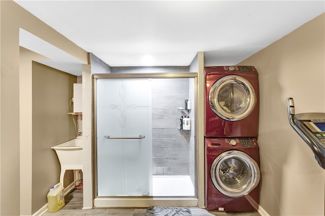 laundry room with stacked washer and clothes dryer and hardwood / wood-style flooring