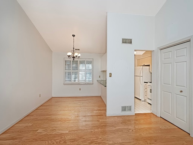 unfurnished dining area featuring light wood-type flooring and an inviting chandelier