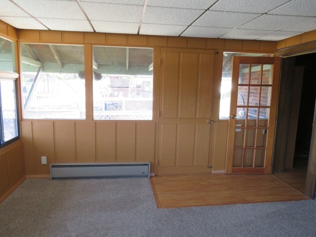 spare room featuring a paneled ceiling, hardwood / wood-style floors, and a baseboard radiator