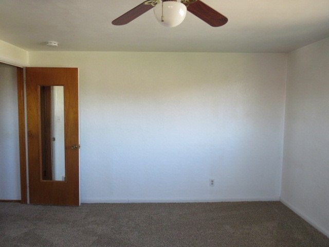 spare room with ceiling fan and carpet