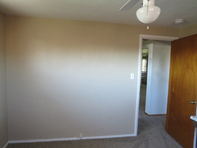 carpeted spare room featuring ceiling fan