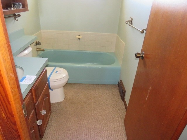 bathroom featuring vanity, toilet, and a bathing tub