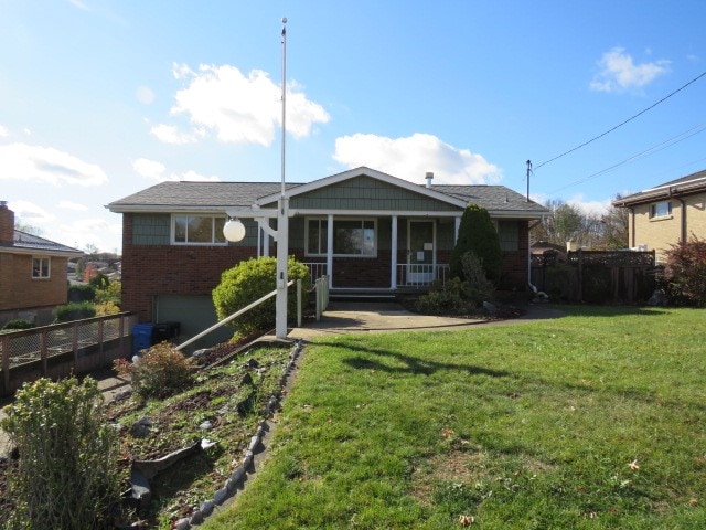 view of front facade with a porch, a garage, and a front yard