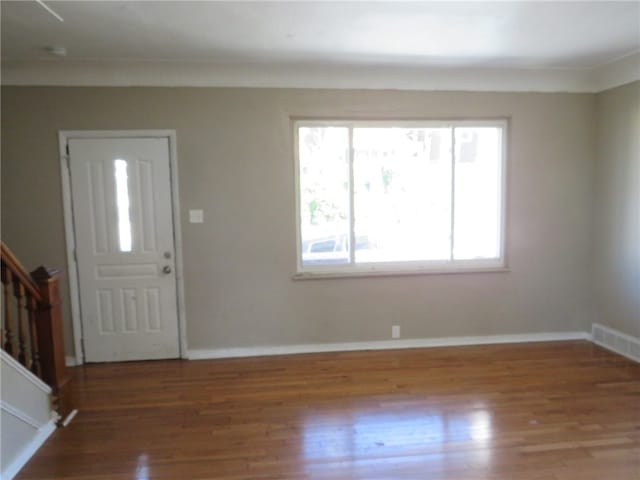 foyer featuring wood-type flooring and ornamental molding