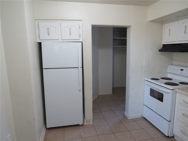 kitchen featuring light tile patterned flooring, white appliances, and white cabinetry