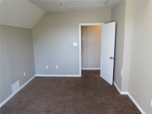 additional living space featuring lofted ceiling and dark colored carpet