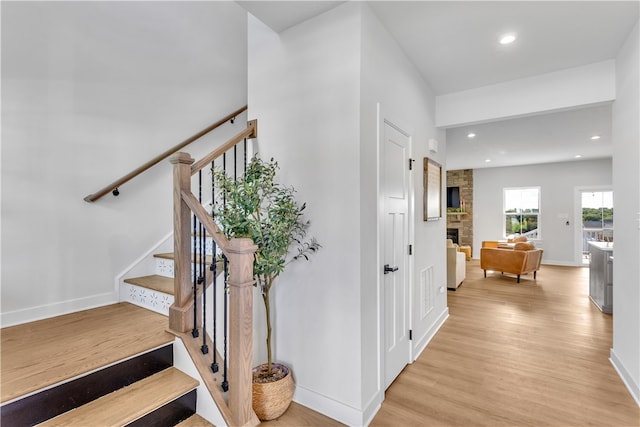 stairs featuring a fireplace and hardwood / wood-style flooring