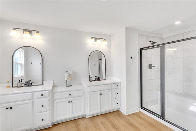 bathroom with hardwood / wood-style floors, an enclosed shower, and vanity