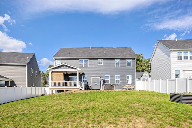 rear view of house with a wooden deck and a lawn