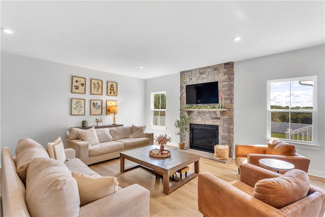 living room with light wood-type flooring and a fireplace