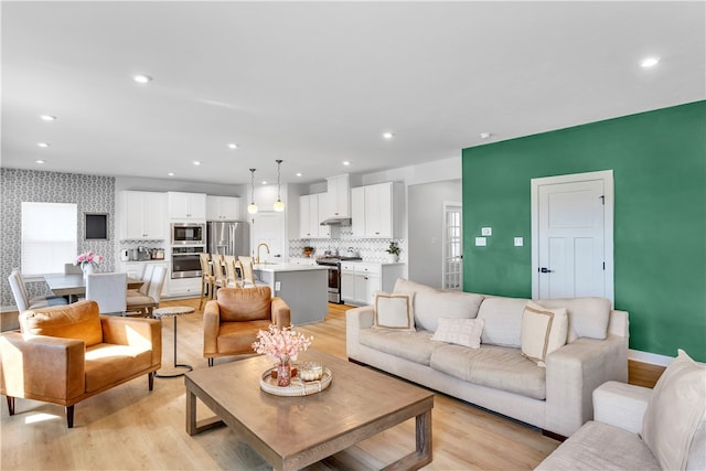 living room featuring sink and light hardwood / wood-style floors