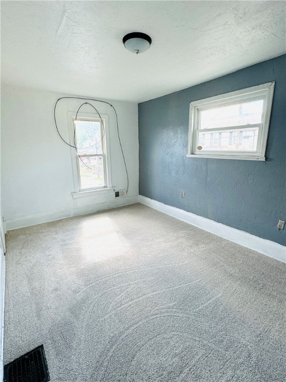 unfurnished room with a healthy amount of sunlight and carpet floors