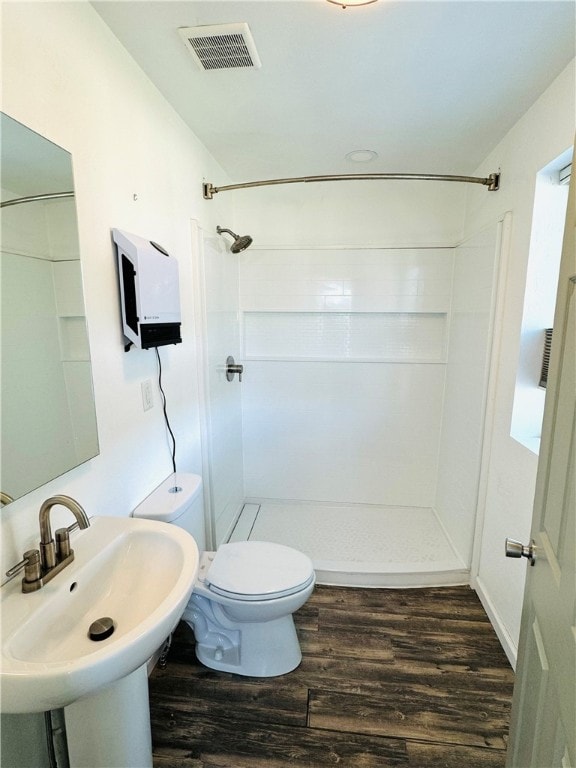 bathroom with hardwood / wood-style floors, sink, walk in shower, and toilet