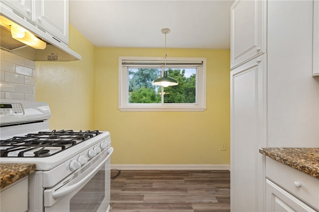 kitchen with white cabinets, pendant lighting, gas range gas stove, and range hood