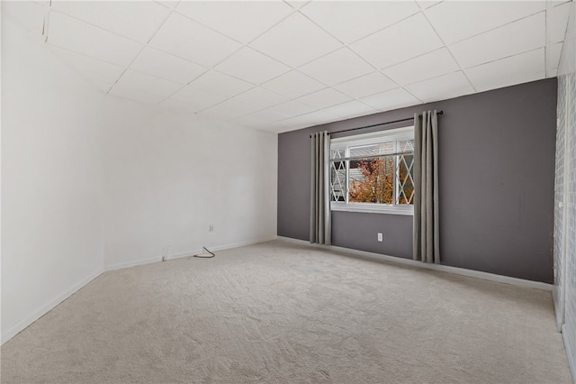 spare room with a drop ceiling and carpet flooring