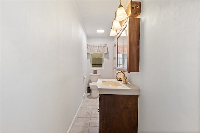 bathroom with tile patterned floors, crown molding, toilet, and vanity