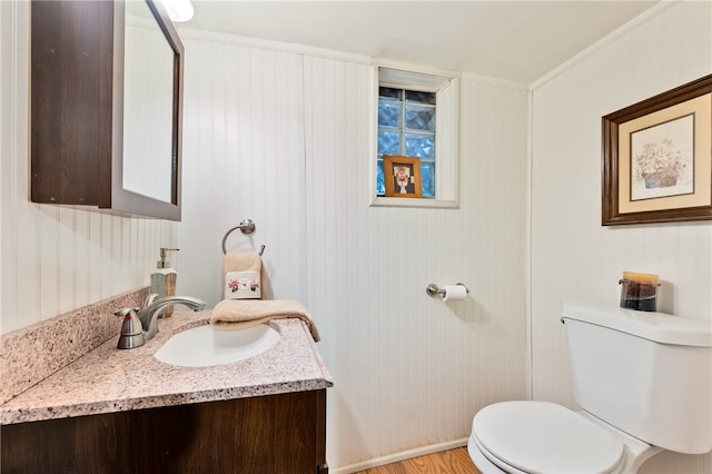 bathroom featuring ornamental molding, vanity, hardwood / wood-style floors, and toilet