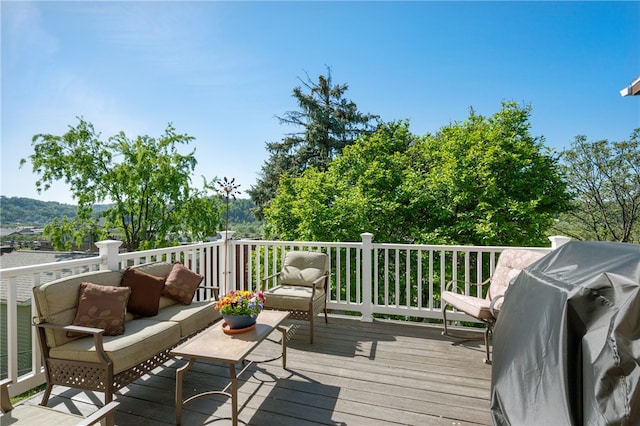 wooden deck featuring outdoor lounge area and a grill