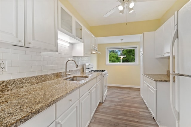 kitchen featuring pendant lighting, sink, white appliances, and white cabinetry