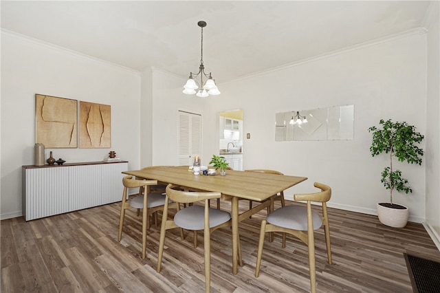 dining space with dark hardwood / wood-style floors, a notable chandelier, and ornamental molding