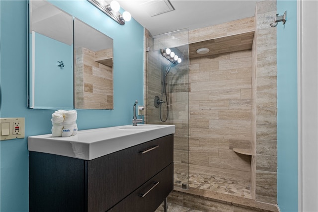 bathroom with vanity and tiled shower