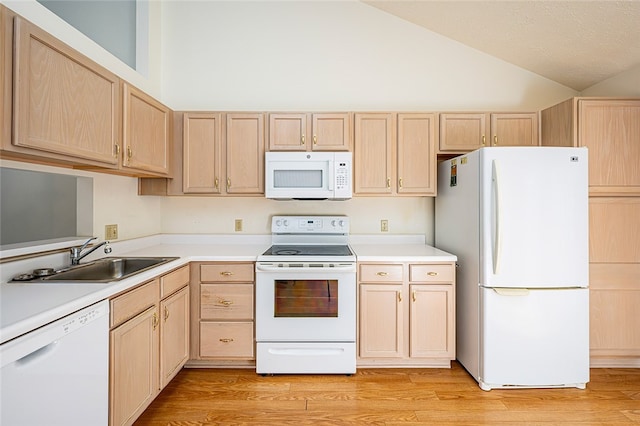 kitchen with sink, light brown cabinetry, white appliances, and light wood-type flooring