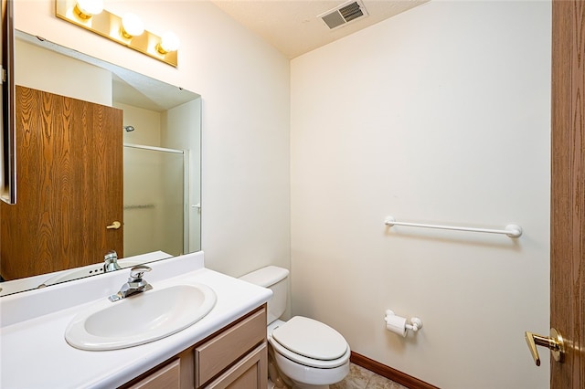 bathroom featuring vanity, an enclosed shower, and toilet