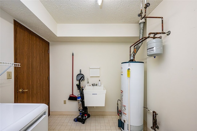 utilities featuring washer / clothes dryer, sink, and gas water heater