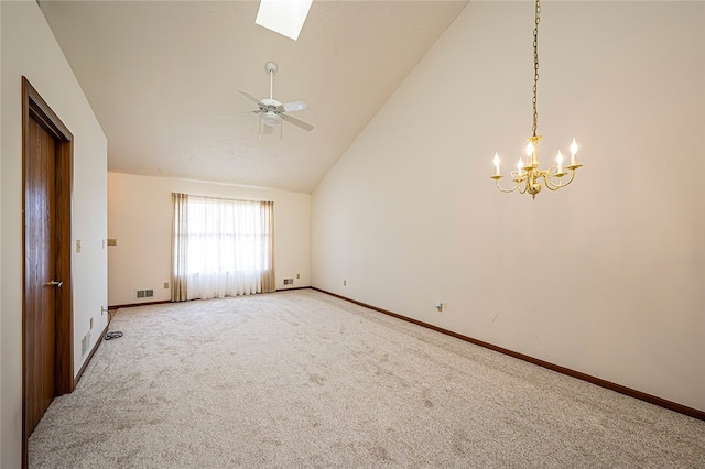 spare room with carpet flooring, ceiling fan with notable chandelier, a skylight, and high vaulted ceiling