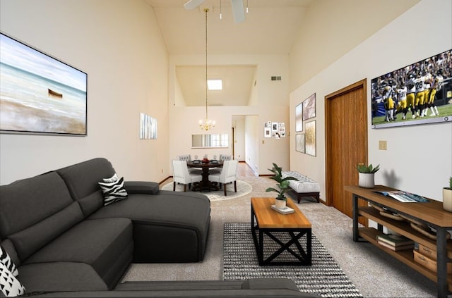 living room featuring carpet flooring, ceiling fan with notable chandelier, and high vaulted ceiling