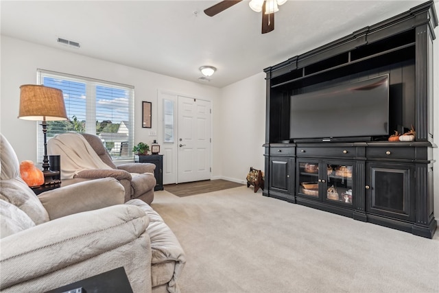 carpeted living room with ceiling fan