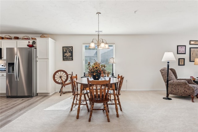 dining room featuring an inviting chandelier and light wood-type flooring